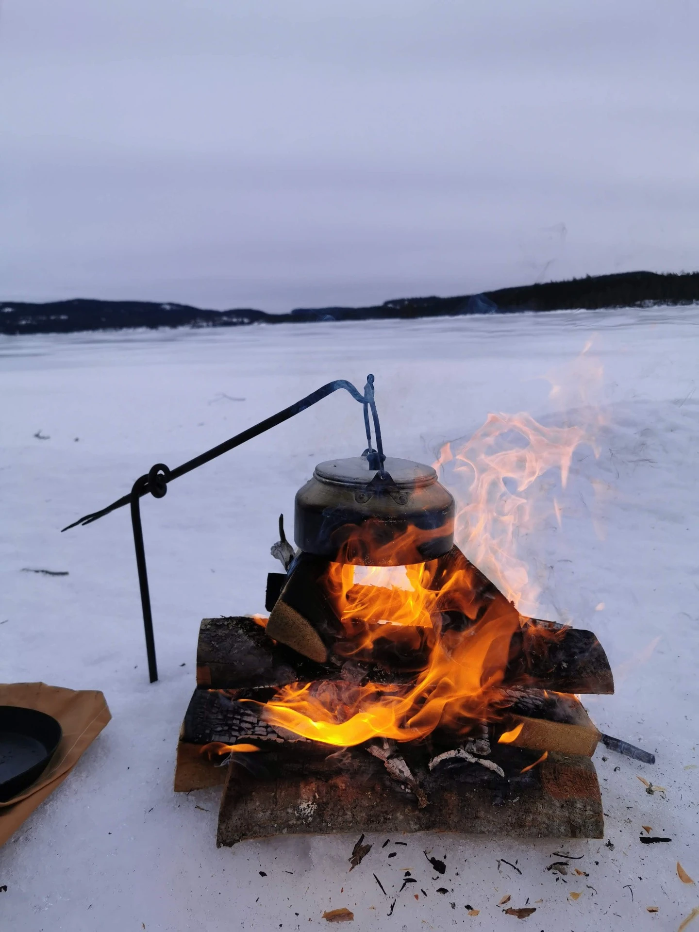 Varm lägereld i snölandskap med gnistor som stiger mot natthimlen